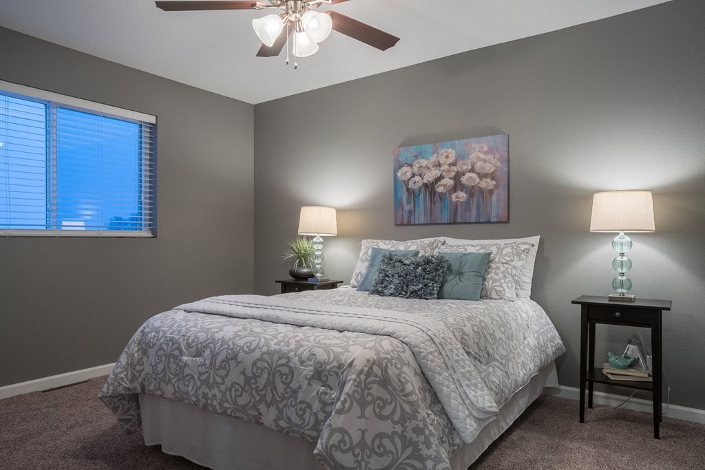 a bedroom with a bed and a ceiling fan