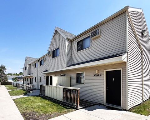 A modern house with a black door and a balcony.