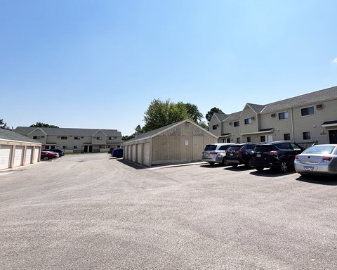 A parking lot with cars and buildings in the background.