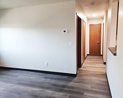 A hallway with a wooden door at the end.