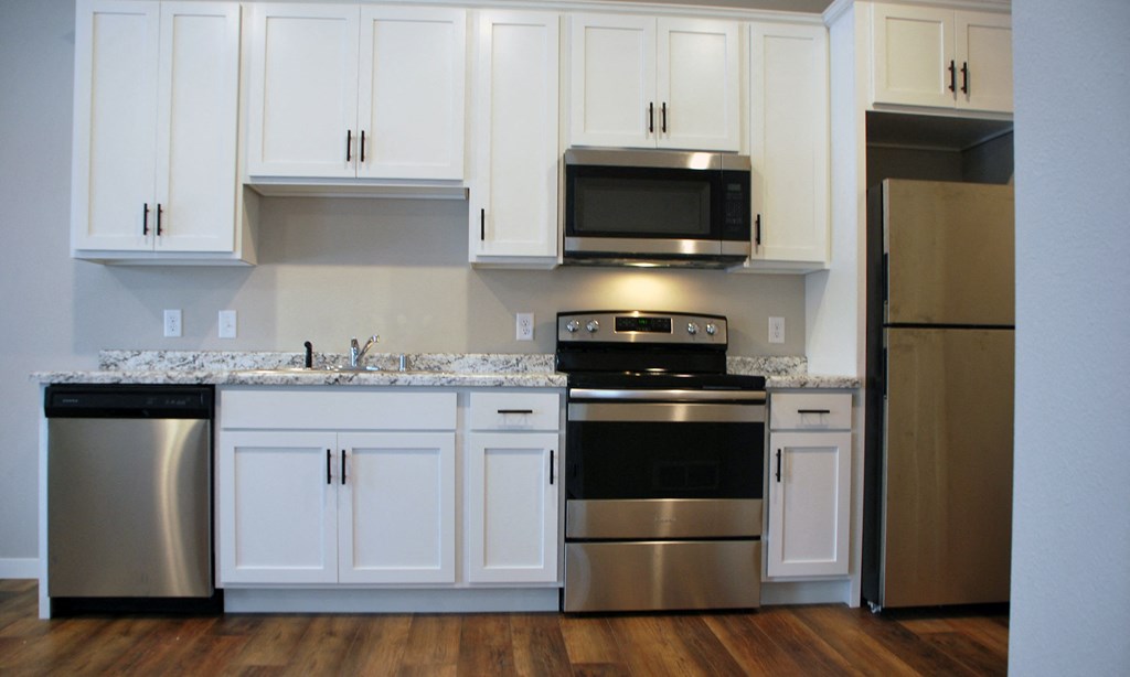 a kitchen with white cabinets and stainless steel appliances