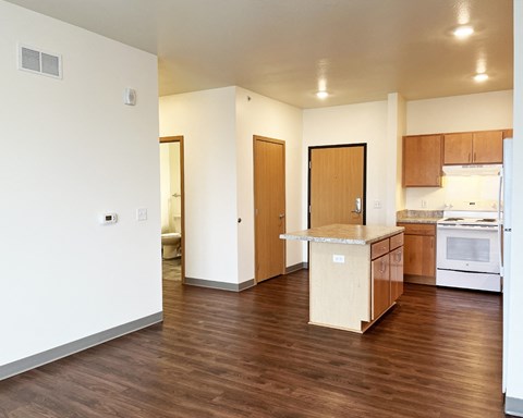 A kitchen with wooden floors and white walls.