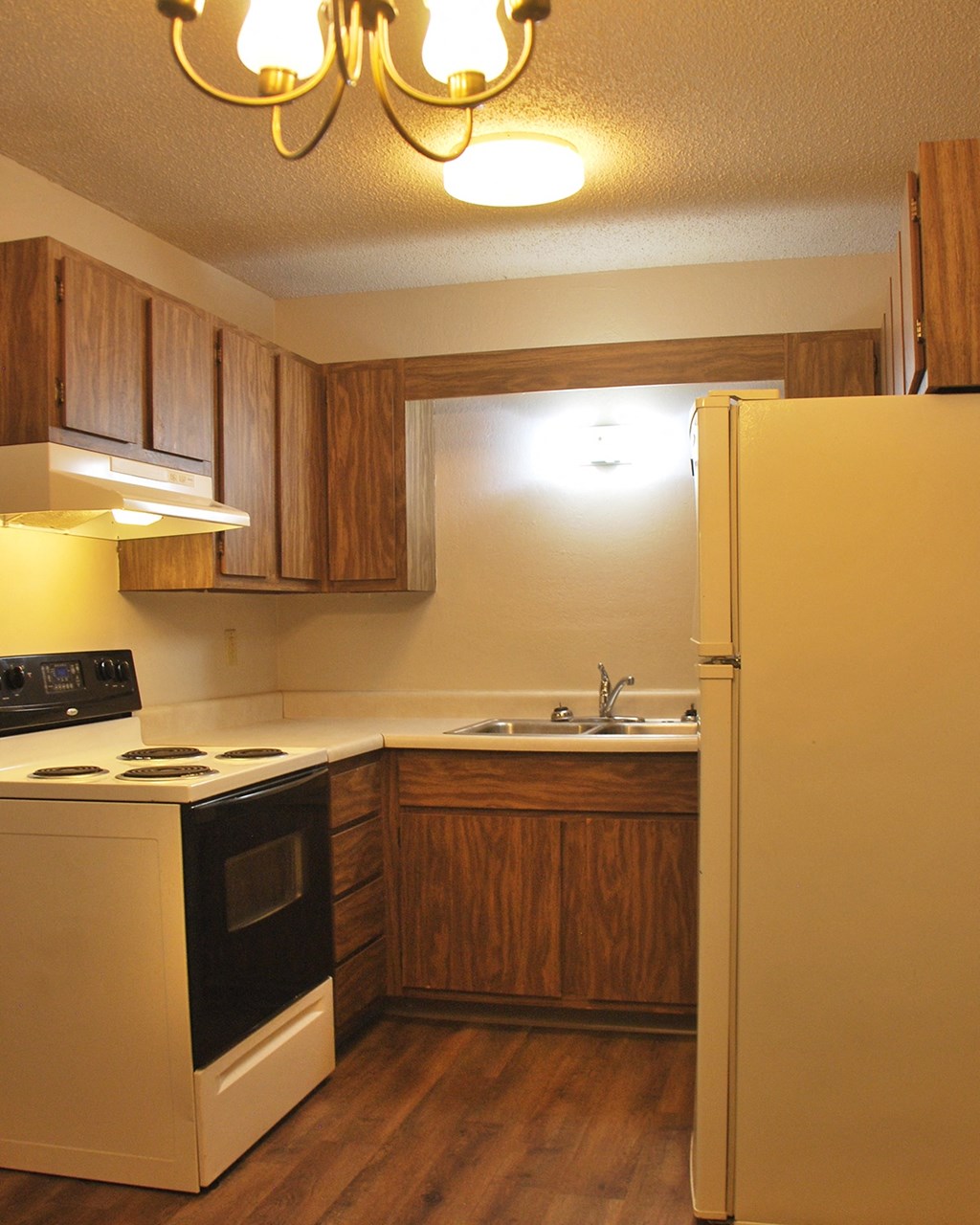 a kitchen with a stove refrigerator and sink