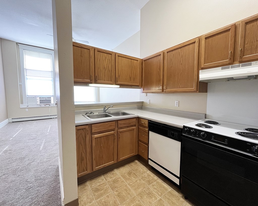 A kitchen with wooden cabinets and black appliances.