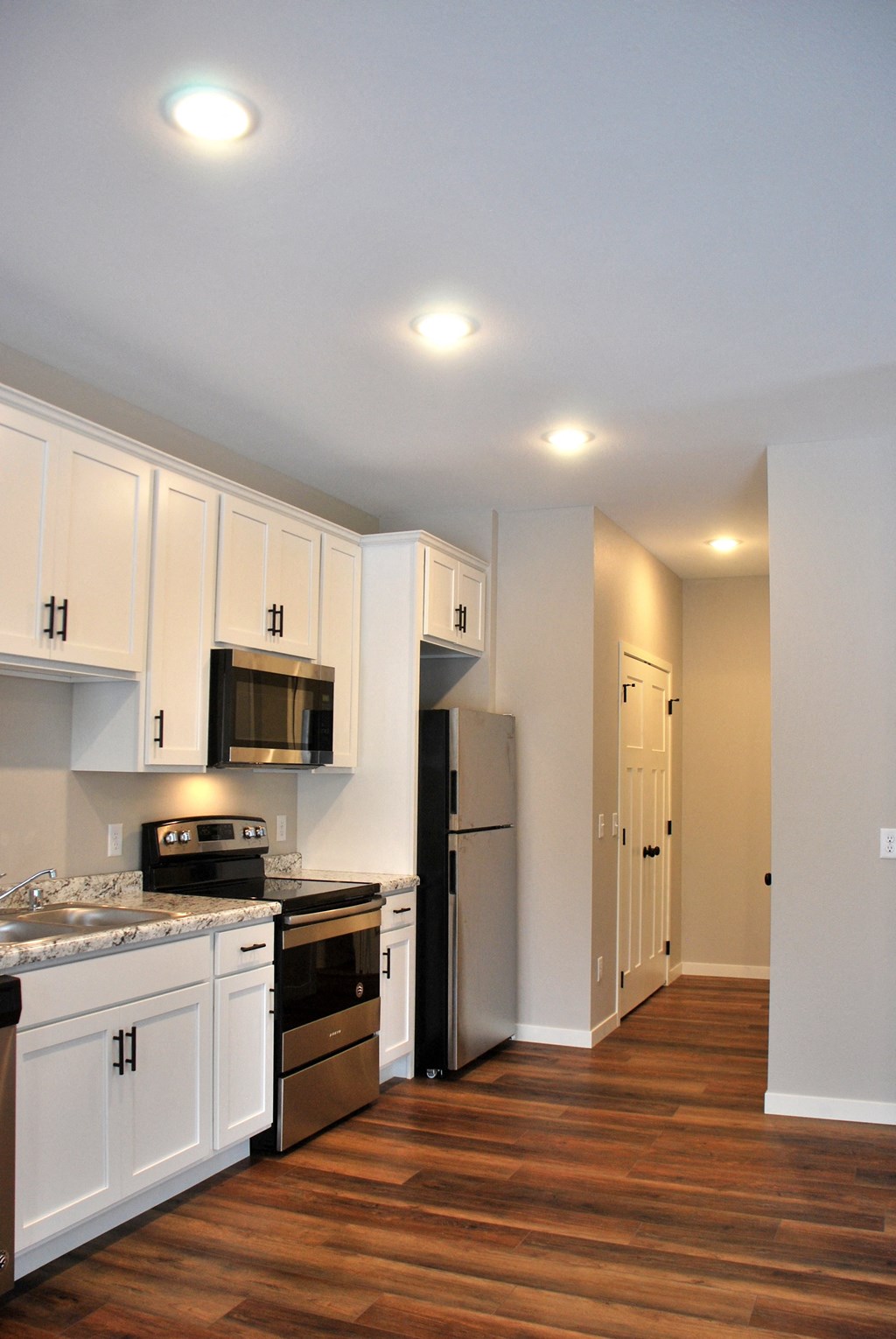 a kitchen with white cabinets and stainless steel appliances