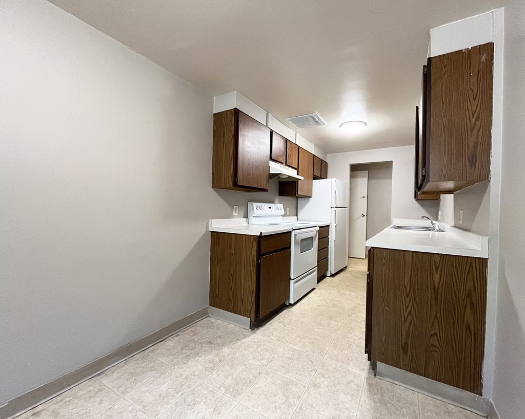 a kitchen with white appliances and wooden cabinets