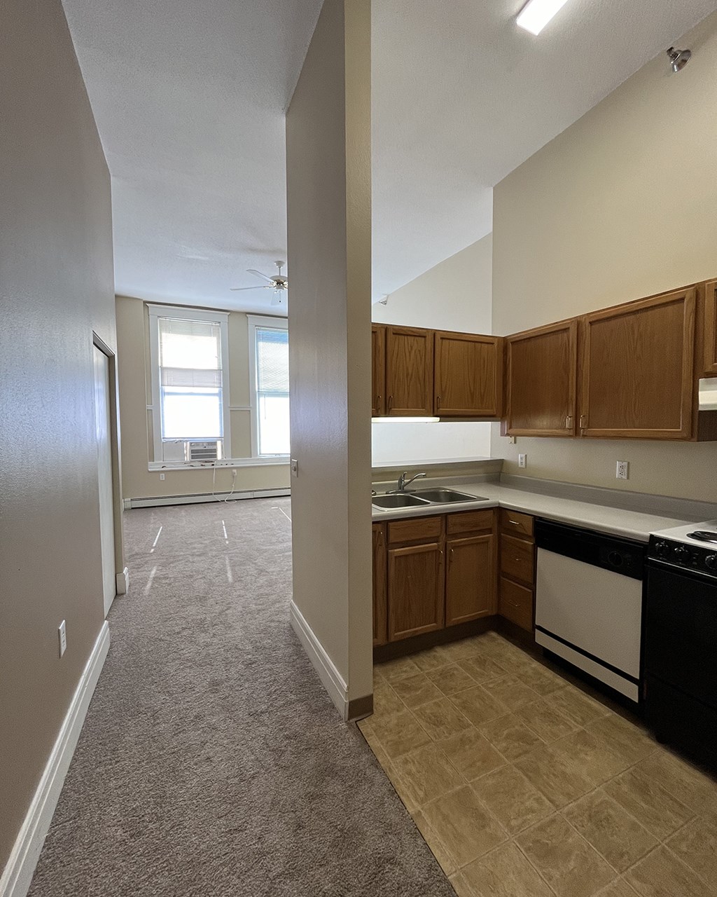 A kitchen with a black dishwasher and white stove.