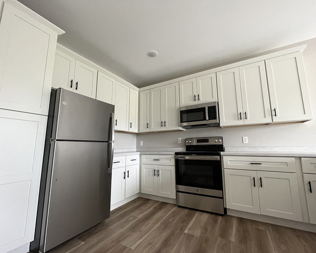 a kitchen with white cabinets and stainless steel appliances
