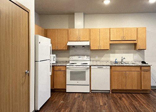 a kitchen with white appliances and wooden cabinets