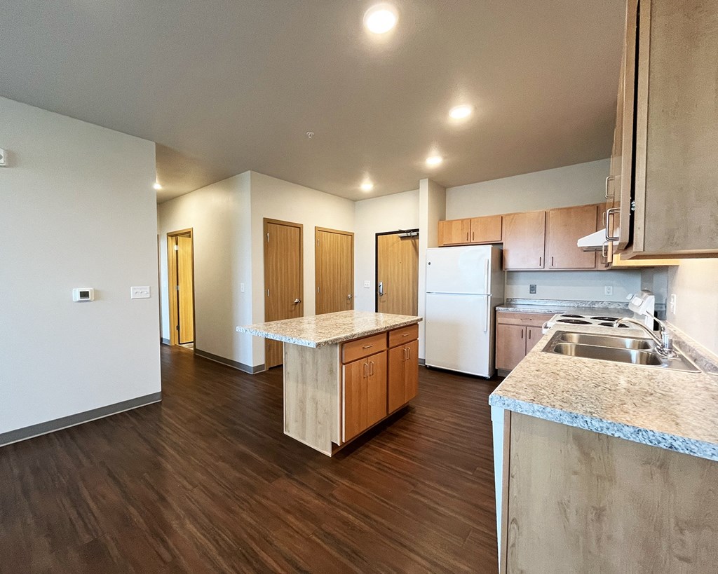 A kitchen with a white fridge and wooden cabinets.