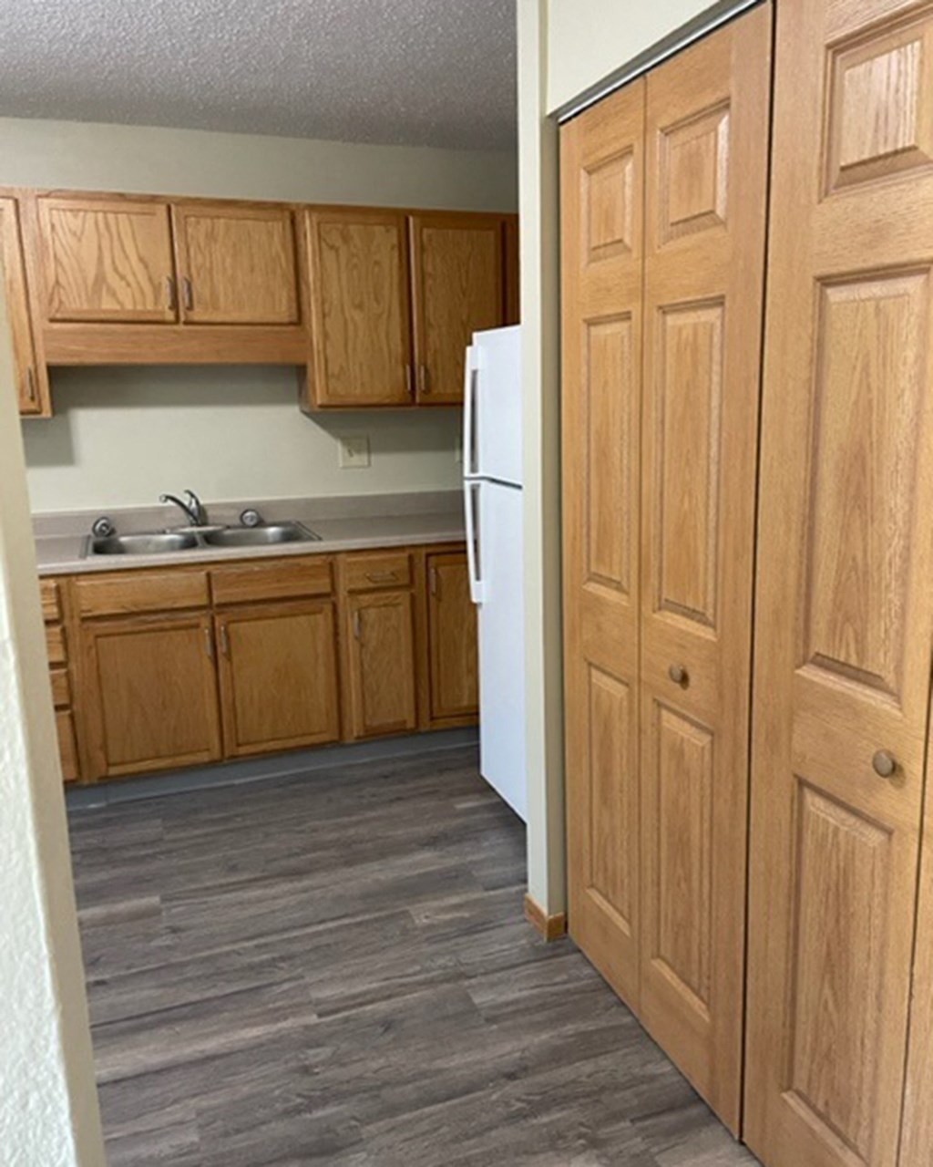 a kitchen with wooden cabinets and a white refrigerator