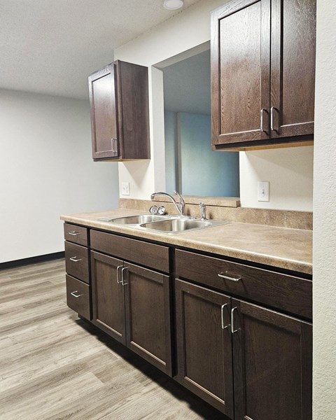 A kitchen with brown cabinets and a sink.