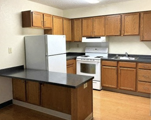 A kitchen with wooden cabinets and a black countertop.