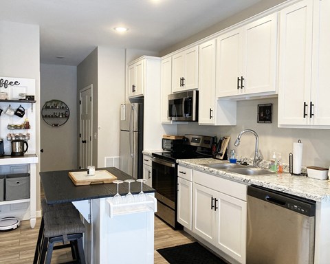 a kitchen with white cabinets and stainless steel appliances and a counter top