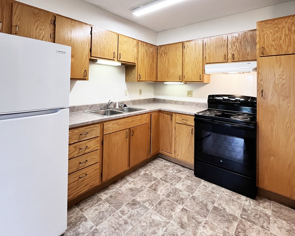 A kitchen with wooden cabinets and a black stove top oven.