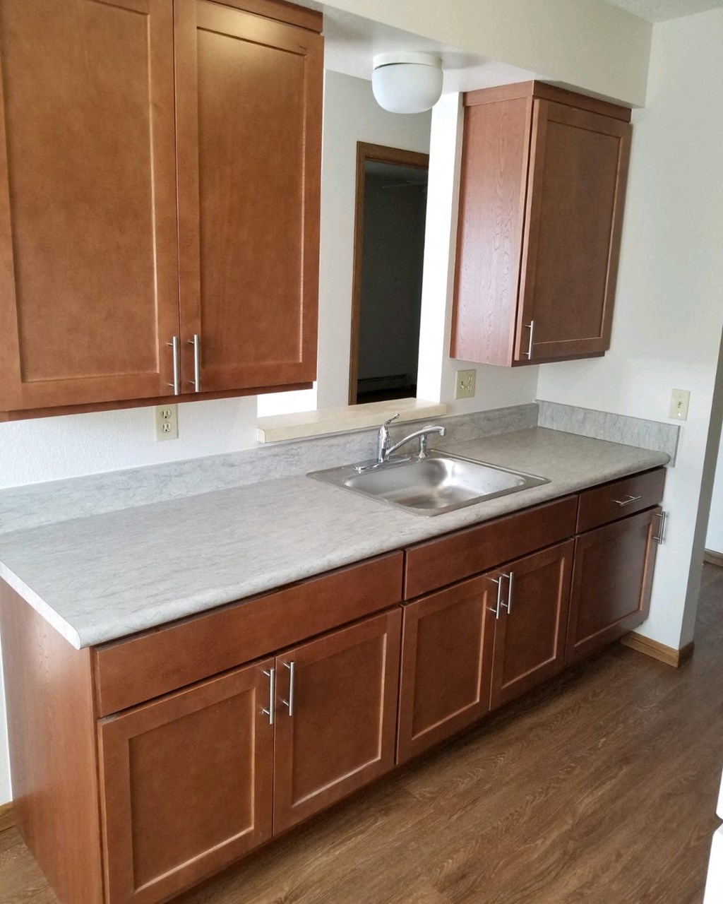 an empty kitchen with wooden cabinets and a sink