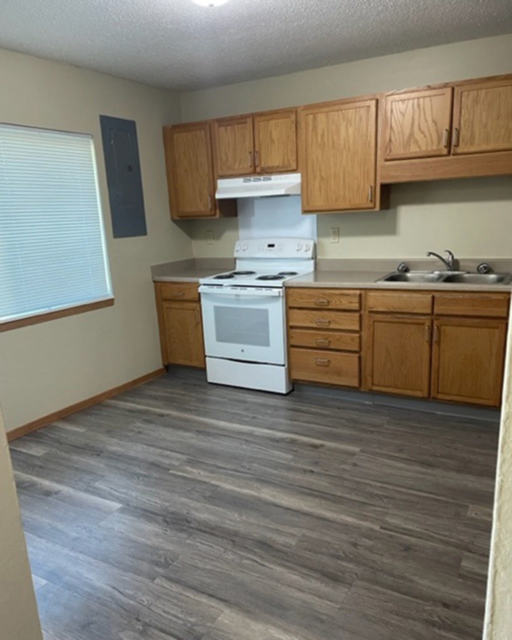 a kitchen with a stove and a sink and wooden cabinets