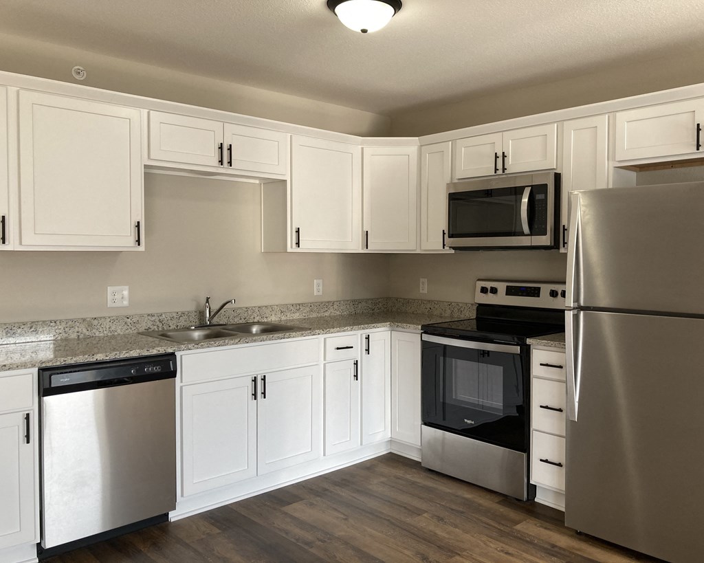 a kitchen with white cabinets and stainless steel appliances