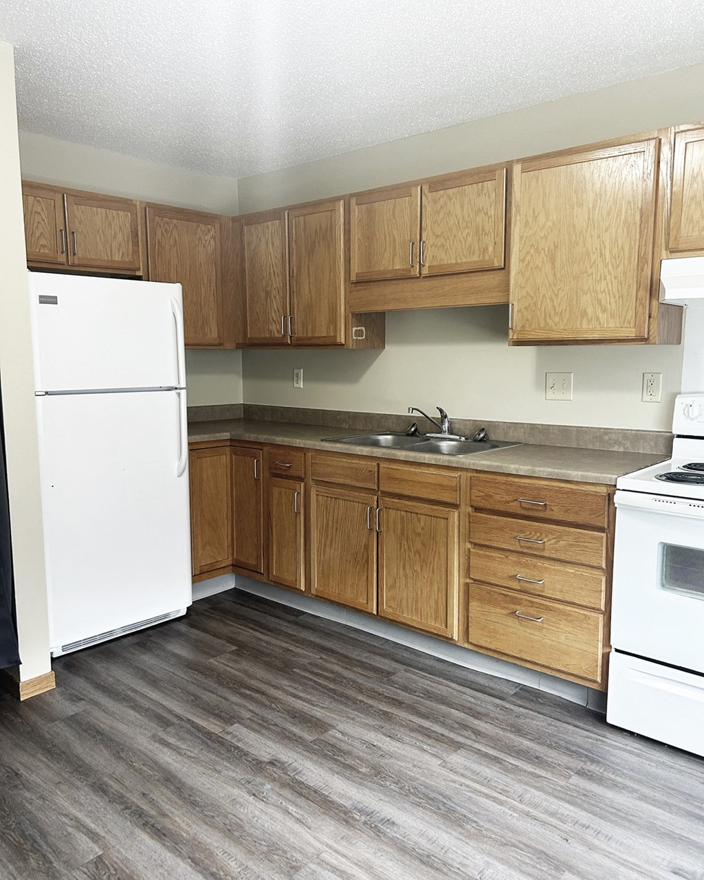 A kitchen with wooden cabinets and a white refrigerator.