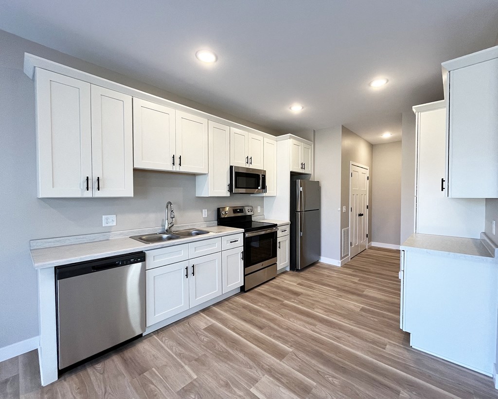 a kitchen with white cabinets and stainless steel appliances