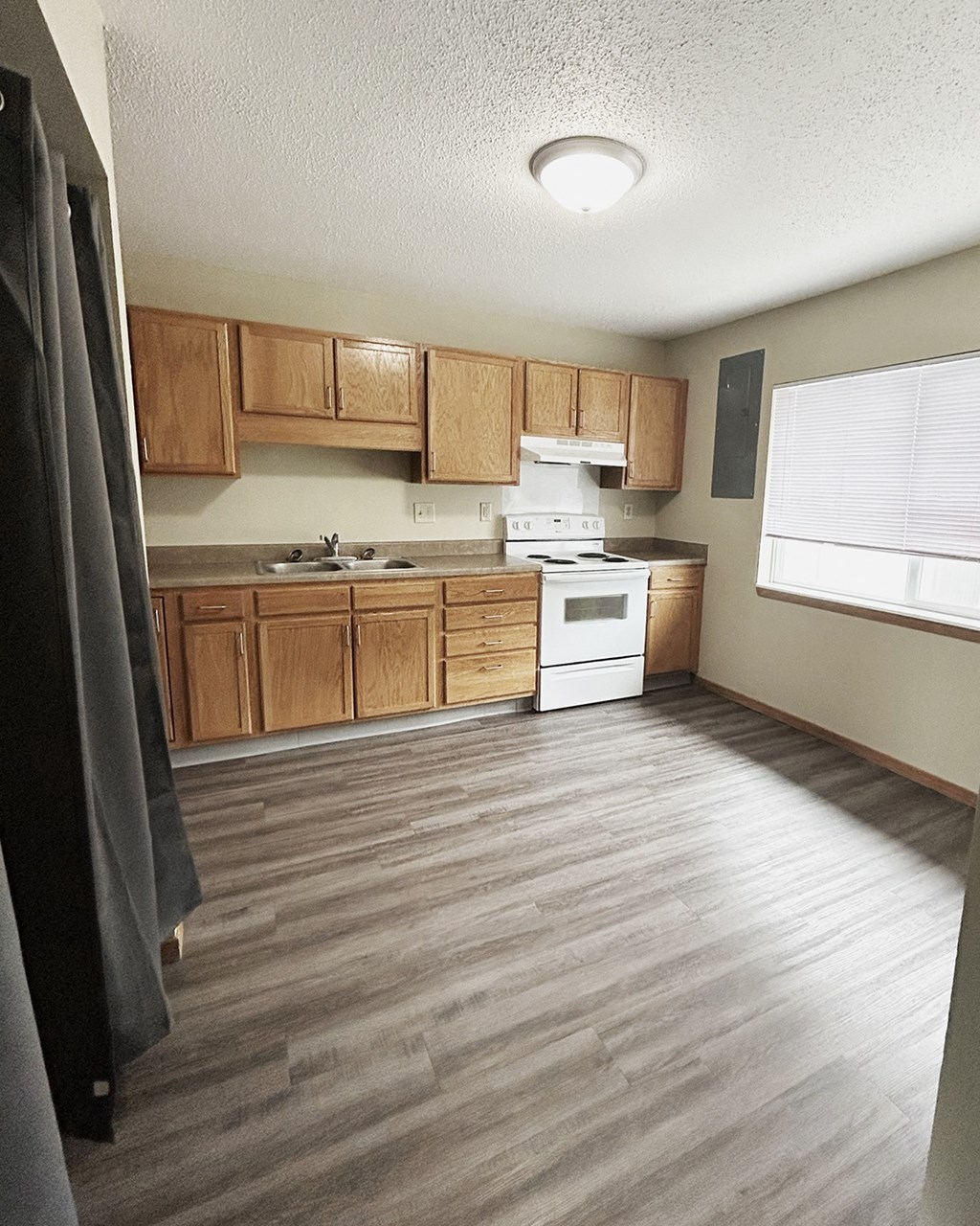 A kitchen with wooden cabinets and a white stove top oven.