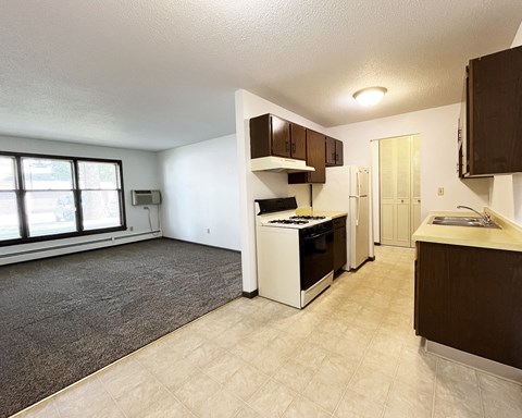 an empty kitchen and living room with a large window and