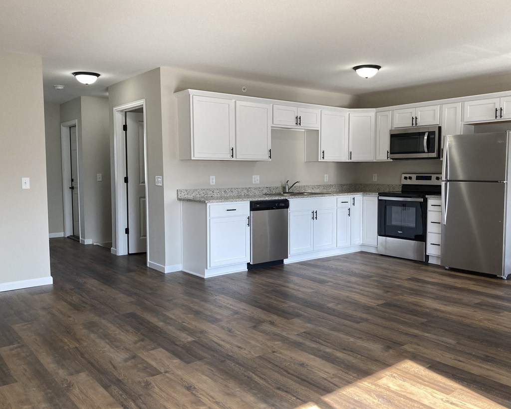 a kitchen with white cabinets and stainless steel appliances