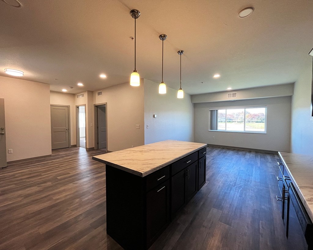 an empty kitchen and living room with a large island