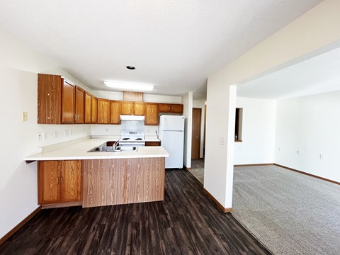 A kitchen with wooden cabinets and a white fridge.