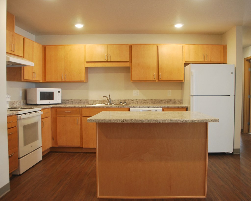a kitchen with a white refrigerator freezer next to a stove top oven
