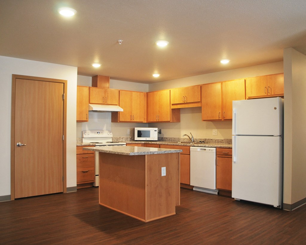 a kitchen with a white refrigerator freezer next to a stove top oven