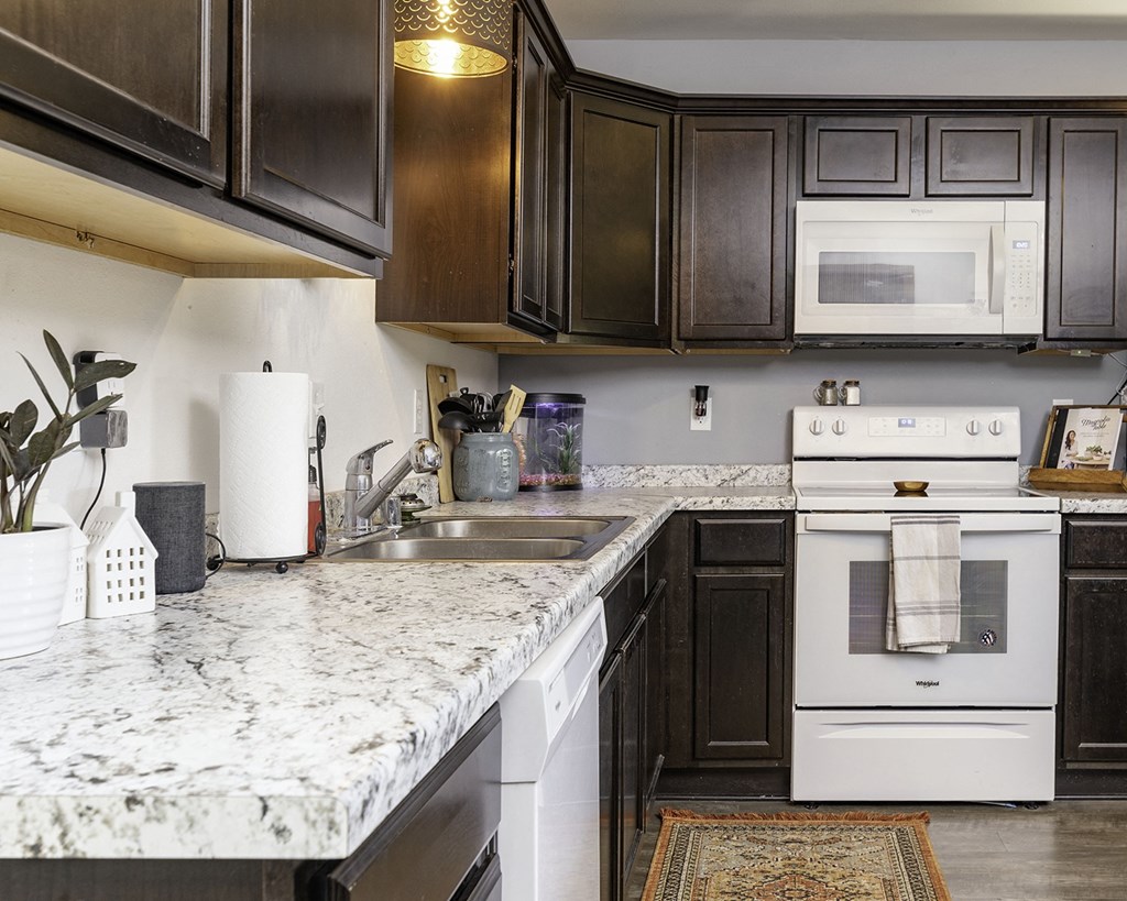 a kitchen with white appliances and marble counter tops