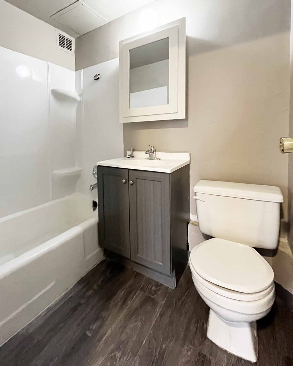 A white toilet sits next to a bathtub in a bathroom.