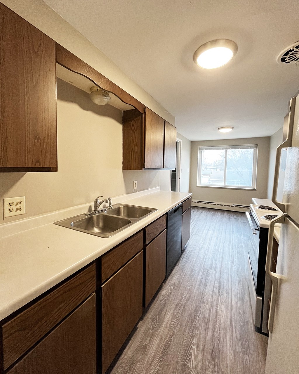 A kitchen with a white sink and a white refrigerator.