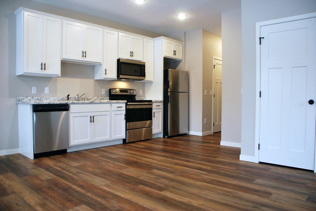 a kitchen with white cabinets and stainless steel appliances
