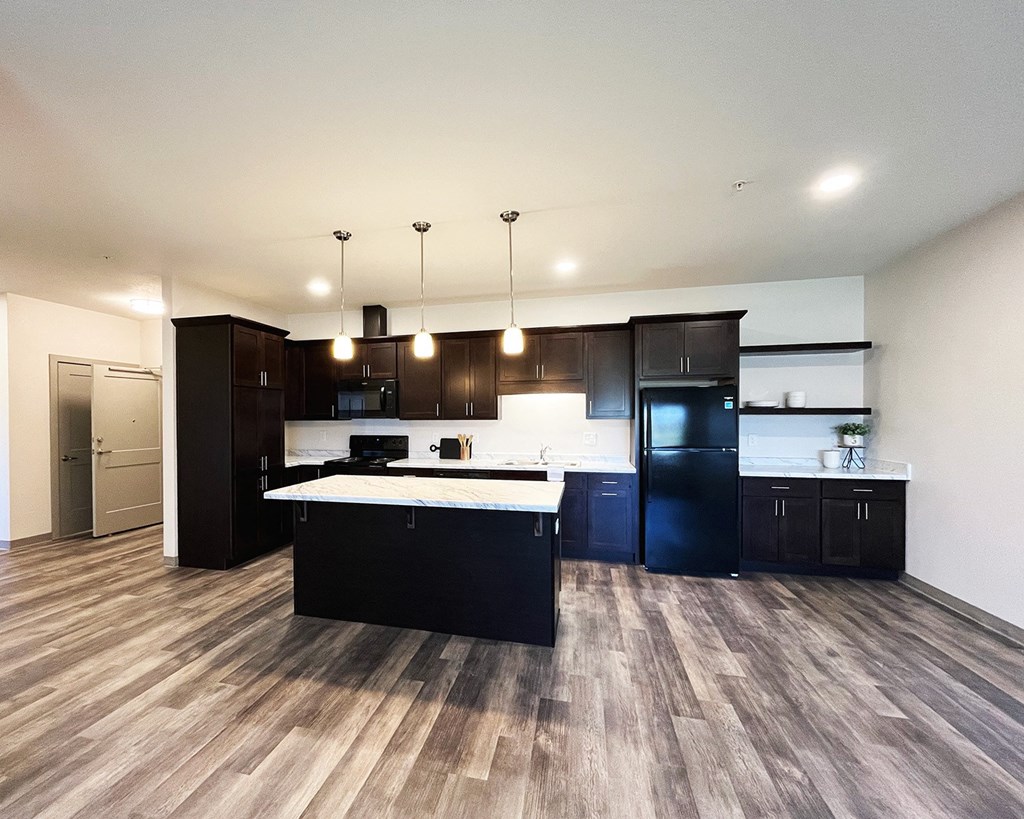 a large kitchen with black appliances and a white counter top