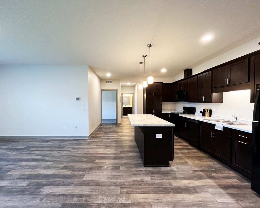 an empty kitchen with a large island in the middle