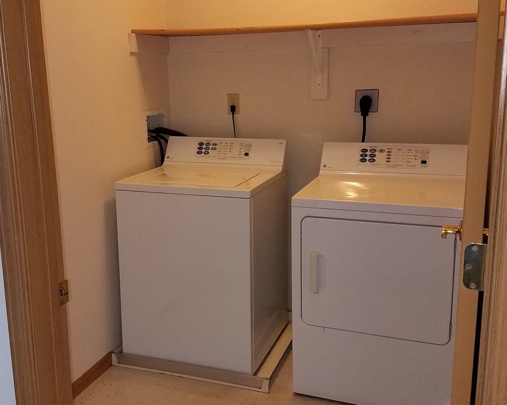 a laundry room with two washes and a dryer