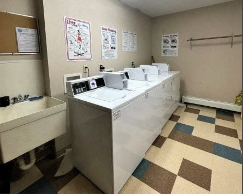 A medical examination room with a white table and brown and blue checkered floor.