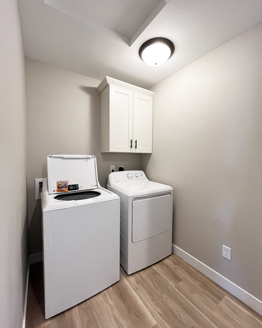 a white washer and dryer in a room with a white cabinet and a