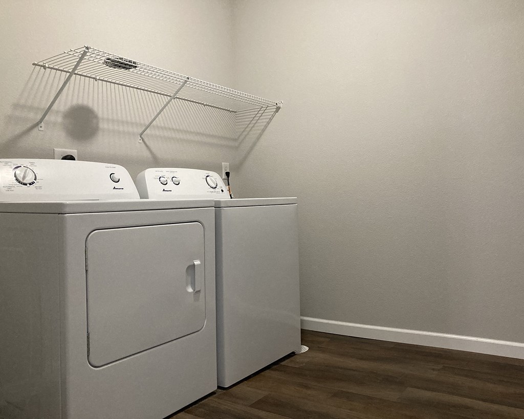 a washer and dryer in a room with a wood floor