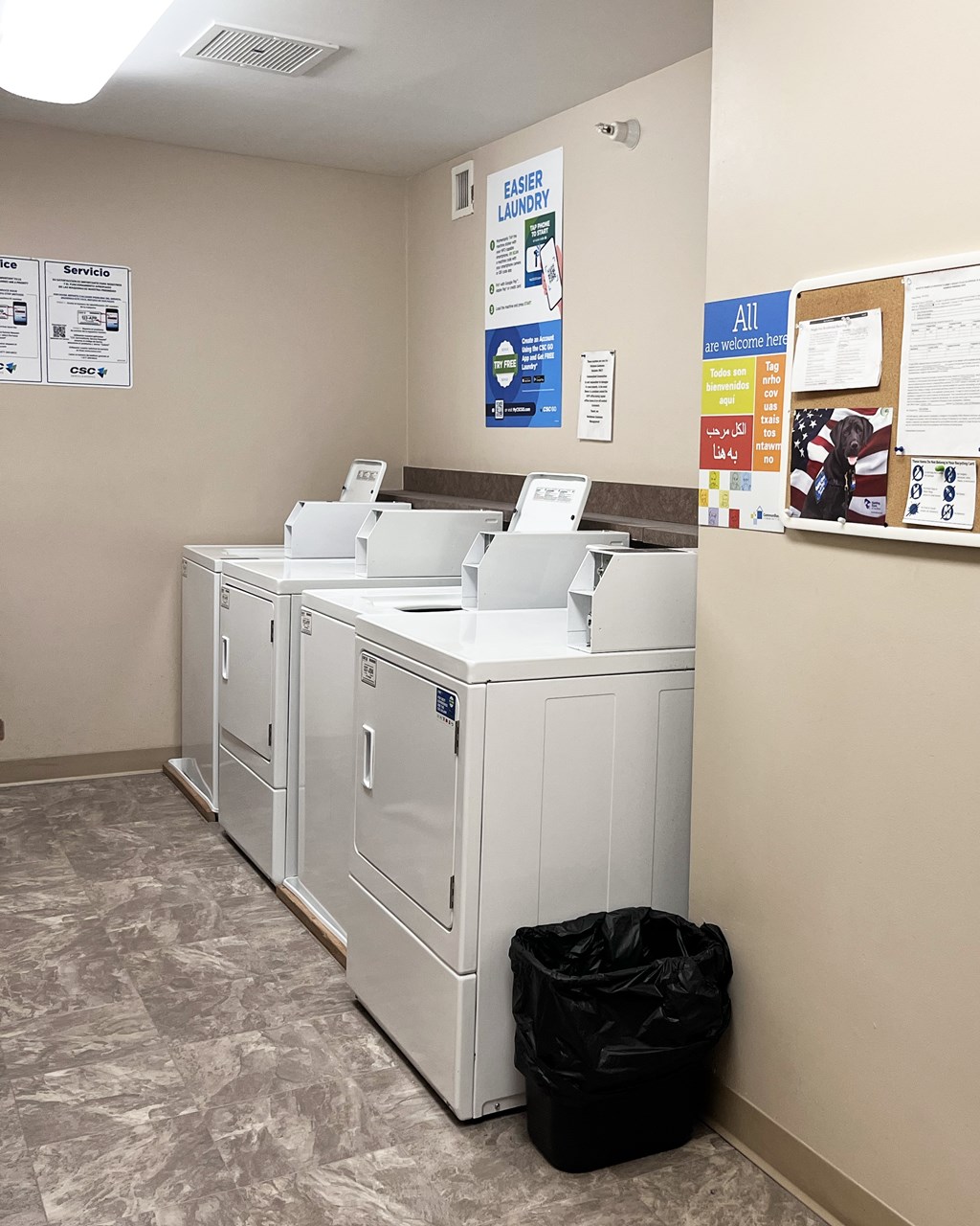 A row of white washing machines are lined up in a room.