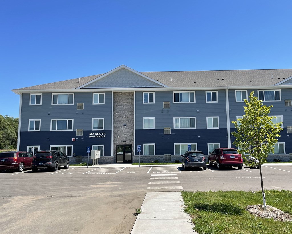 a large blue building with cars parked in front of it