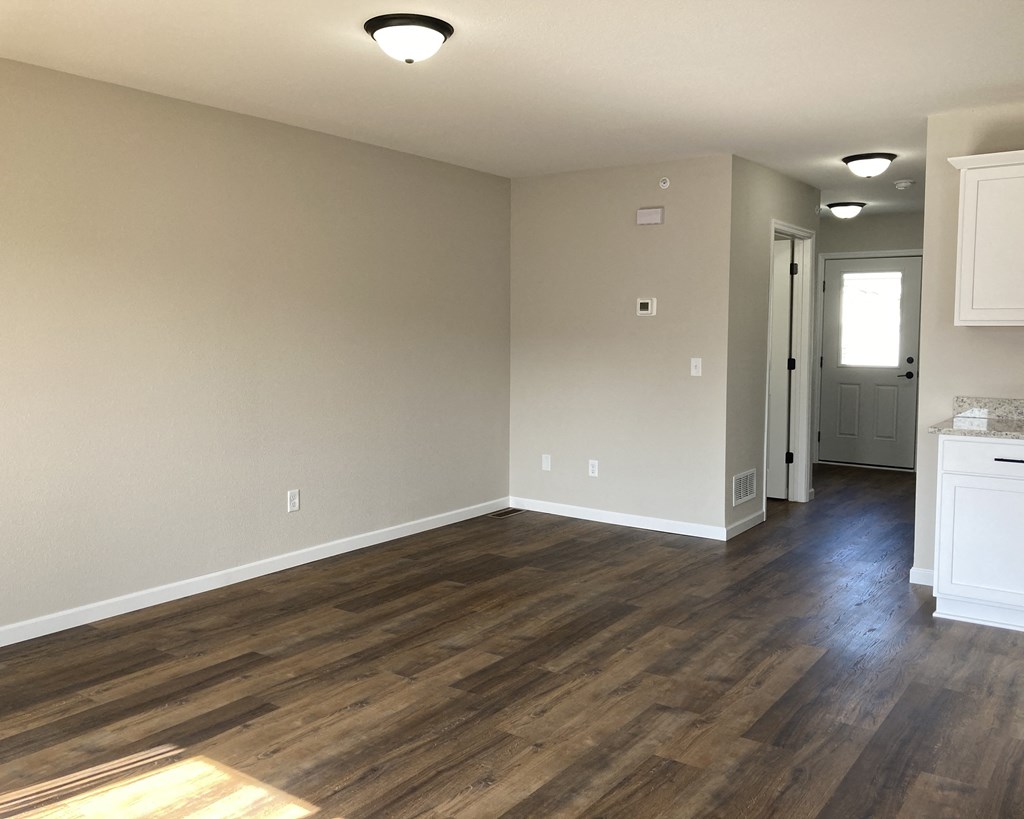a bedroom with hardwood floors and grey walls
