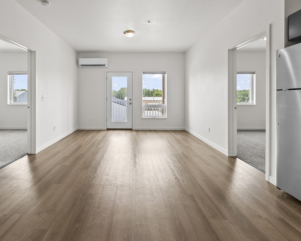 an empty living room with white walls and wood floors