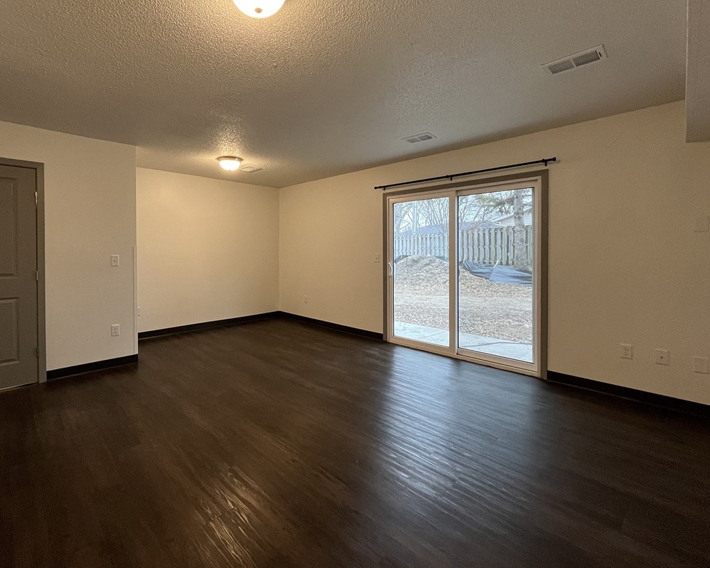 the living room of an empty house with a sliding glass door
