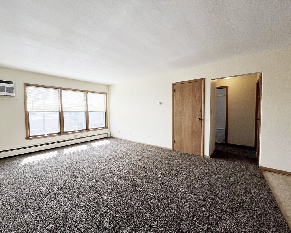 an empty living room with a window and a door