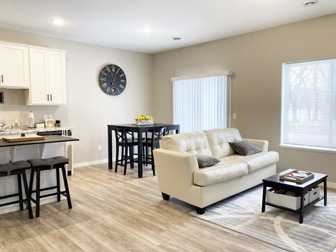 a living room with a couch and a kitchen with a table and chairs