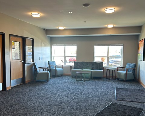 an empty waiting room in a hospital with chairs and couches