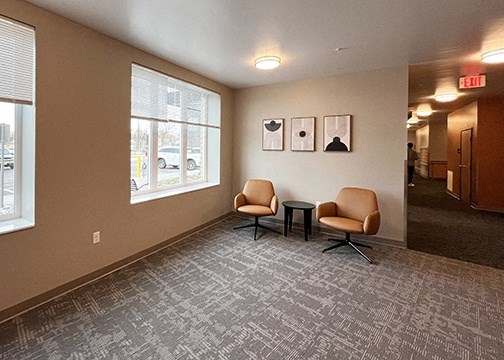 a room with two chairs and a table in front of a window